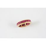 A RUBY FULL CIRCLE ETERNITY RING mounted with calibre-cut rubies in 18ct yellow gold. Size L