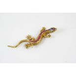 A GOLD AND GEM SET LIZARD BROOCH the gold body mounted with graduated circular-cut rubies, an oval-