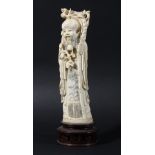 CHINESE IVORY CARVING OF SHOU LAO, early 20th century, modelled standing holding a peach branch