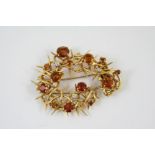 A GOLD, CITRINE AND DIAMOND BROOCH the gold openwork mount is set with circular-cut citrines and