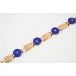 A LAPIS LAZULI AND GOLD BRACELET the 18ct gold bracelet is mounted with lapis discs, with French