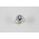 A SAPPHIRE AND DIAMOND CLUSTER RING the oval-shaped sapphire is set within a surround of two