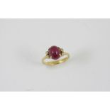 A RUBY AND DIAMOND RING the oval-shaped cabochon ruby is set with two circular-cut diamonds to