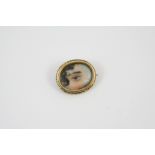 A VICTORIAN EYE MINIATURE BROOCH PENDANT mounted in a foliate gold mount, 2.5cm wide