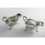 A PAIR OF EARLY GEORGE III SAUCE BOATS on three legs with gadrooned borders and leaf-capped flying