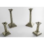 AN EDWARDIAN PAIR OF CANDLESTICKS with Corinthian capitals, fluted columns and stepped square