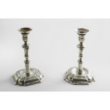 A PAIR OF LATE 18TH CENTURY CANDLESTICKS on shaped and domed square bases with knopped and