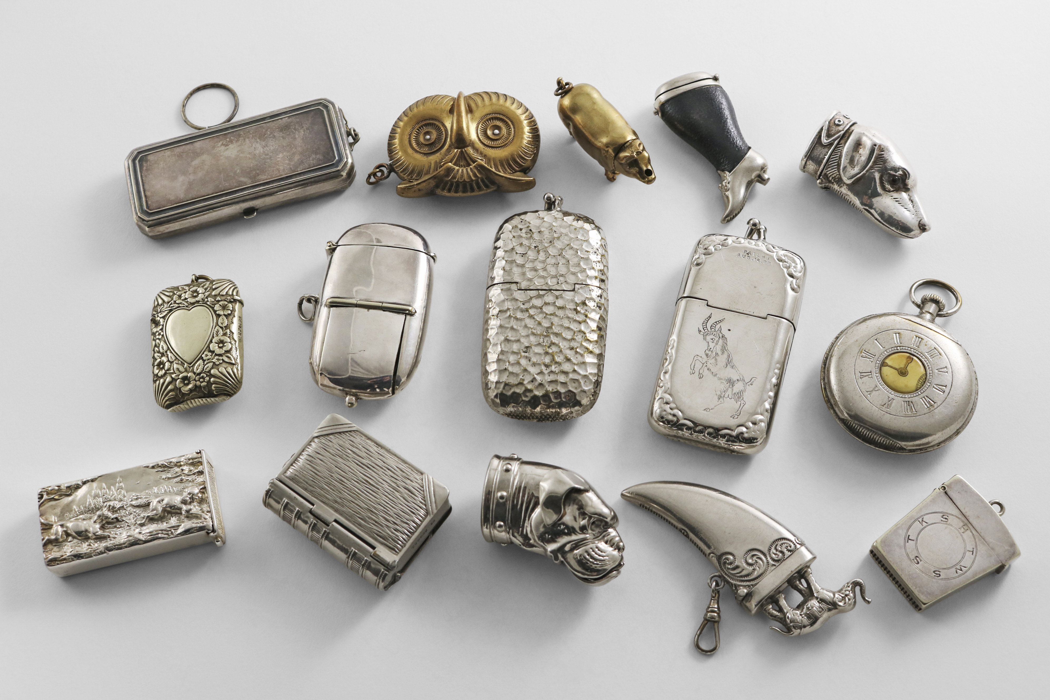 A MIXED LOT OF BRASS, NICKEL-PLATED & ELECTROPLATED VESTA CASES TO INCLUDE:- An owl mask, a pig, two