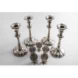 A SET OF FOUR VICTORIAN ELECTROPLATED CANDLESTICKS on shaped circular bases with detachable nozzles,