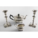 A PAIR OF EDWARDIAN CANDLESTICKS on shaped square bases with knopped and shouldered columns and