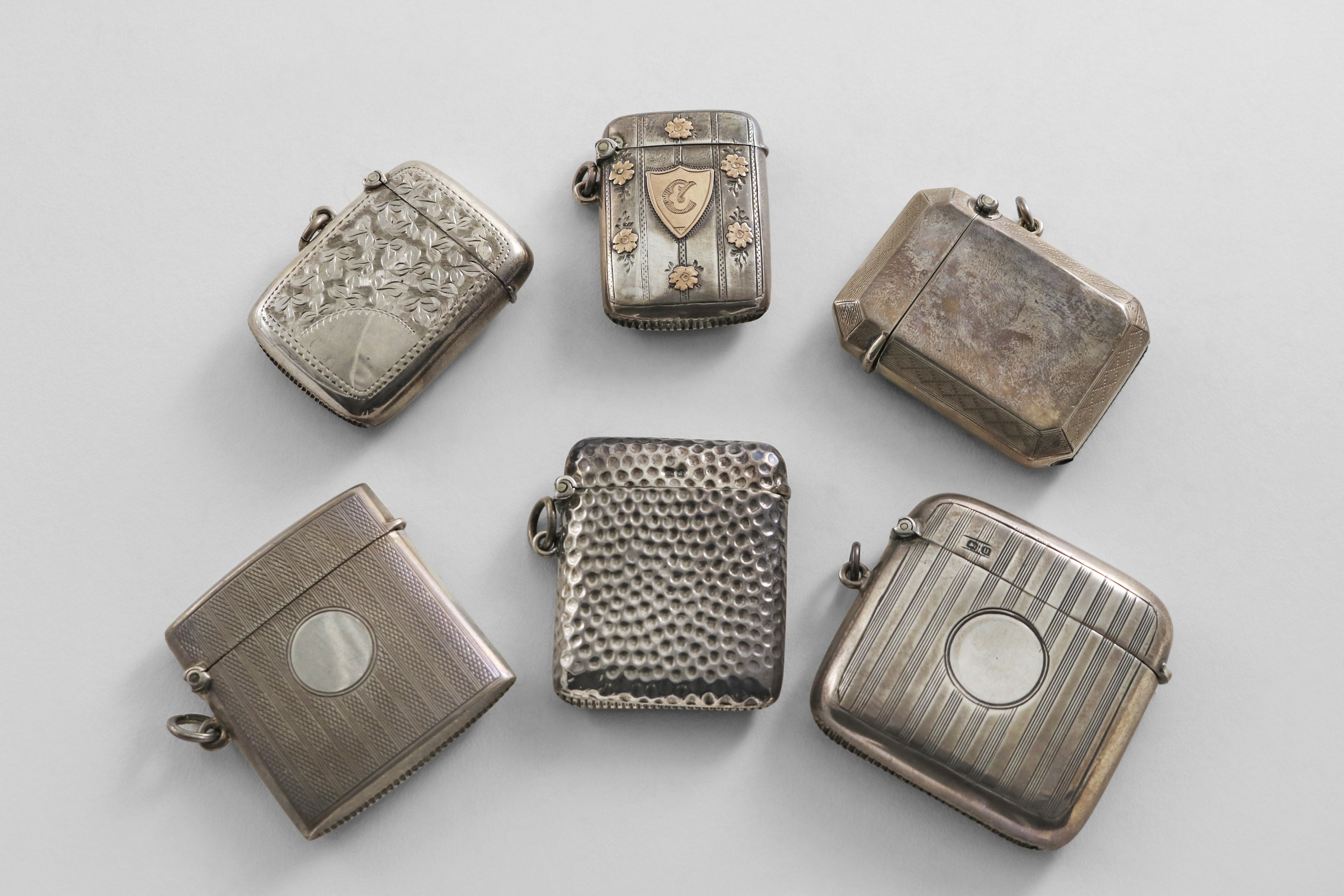 SIX VARIOUS EDWARDIAN & LATER SILVER VESTA CASES of mixed designs, including one with applied gold