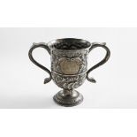 A GEORGE III TWO-HANDLED CUP with later-embossed decoration and a scrollwork cartouche on each side,