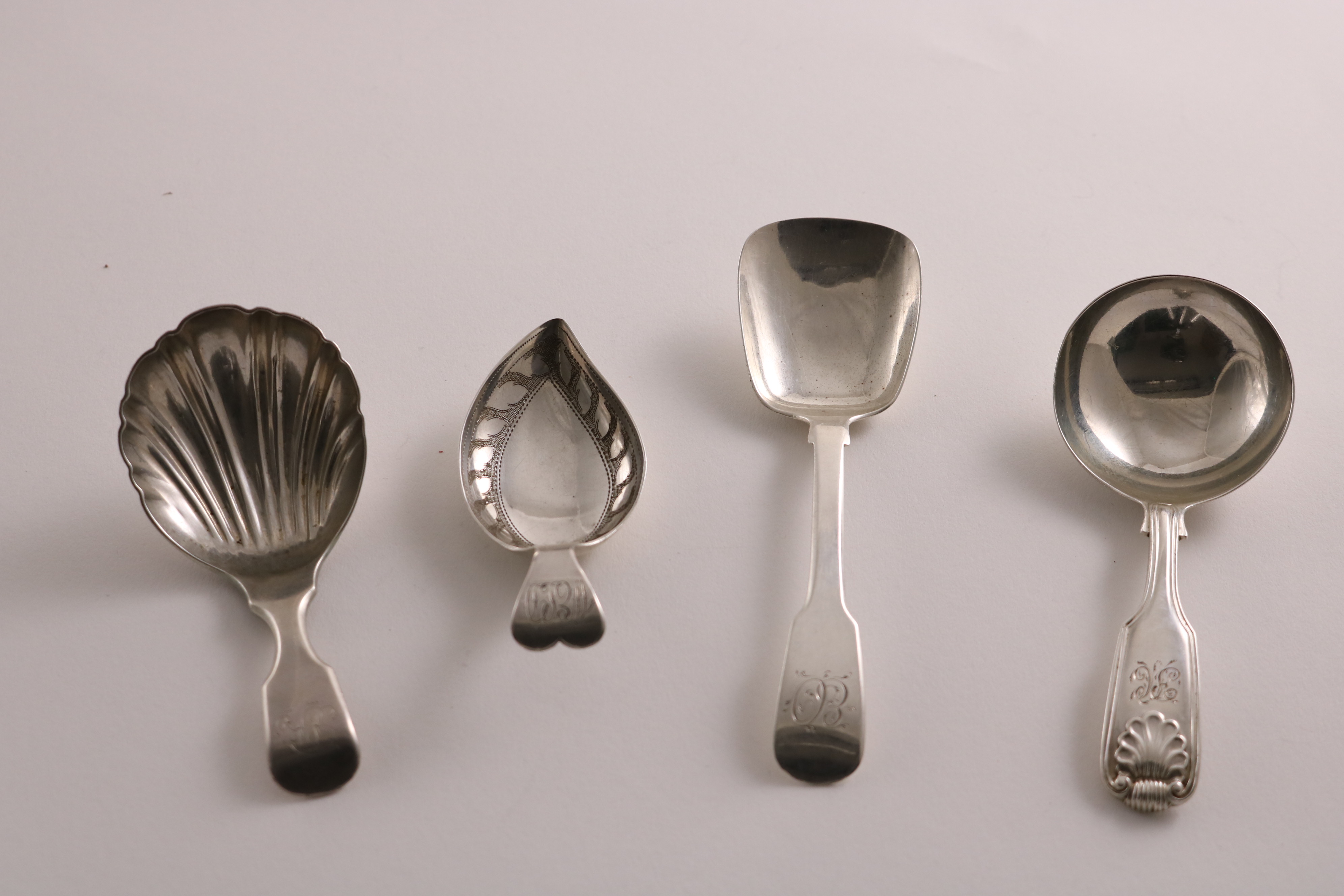 A GEORGE III SILVER CADDY SPOON with a leaf-shaped bowl and an engraved border, initialled, by