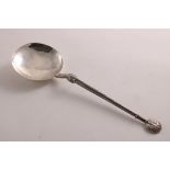 AN EARLY 20TH CENTURY HANDMADE SILVER SPOON with a hammered circular bowl and applied braided and