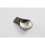 AN EARLY 20TH CENTURY HANDMADE CADDY SPOON with a lug handle, decorated with blue, green, orange and