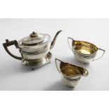 A GEORGE III FOUR-PIECE TEA SET with oval bodies, engraved border decoration and angular handles; to