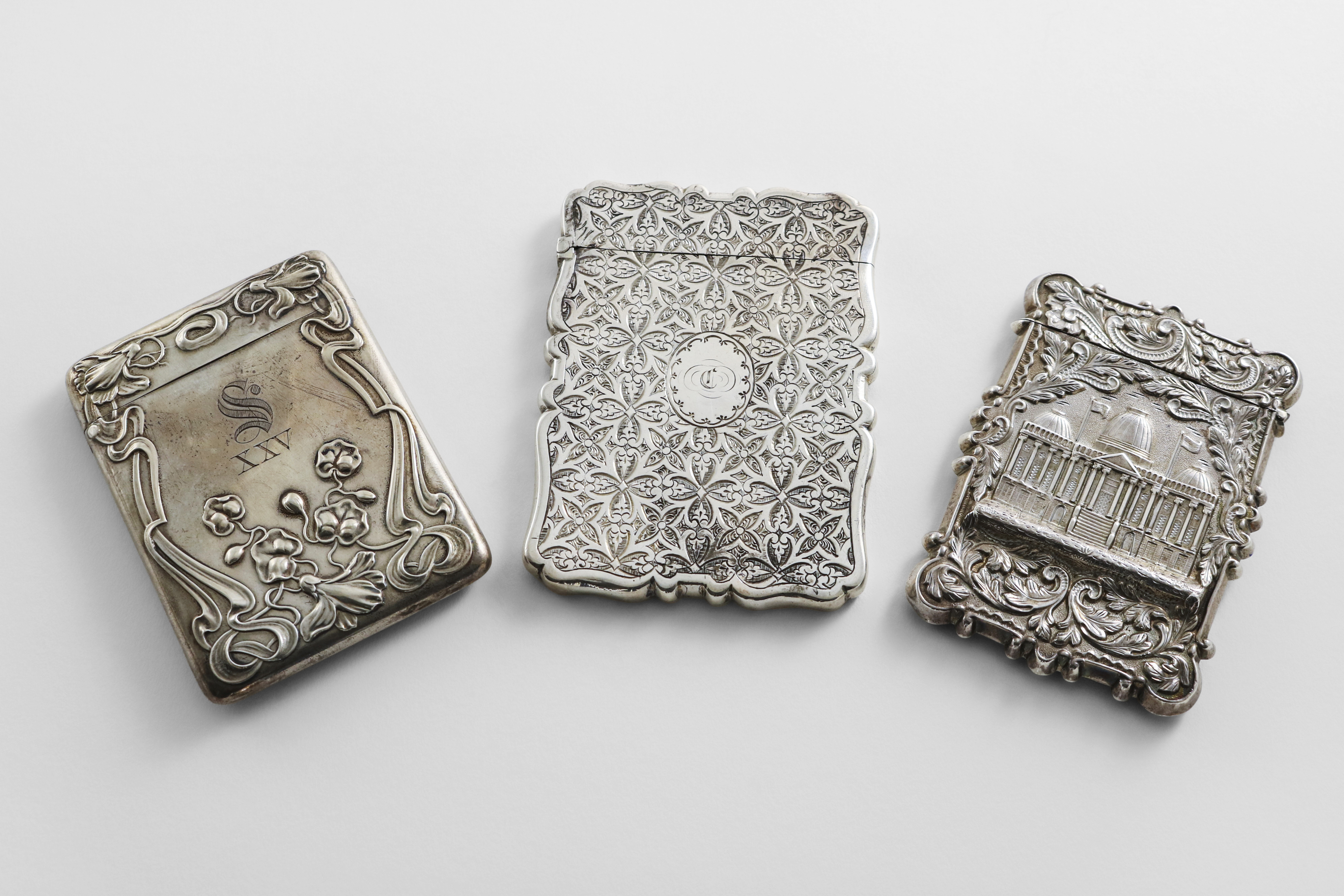 AN AMERICAN SILVER ART NOUVEAU CARD CASE with embossed floral decoration, initialled & numbered "