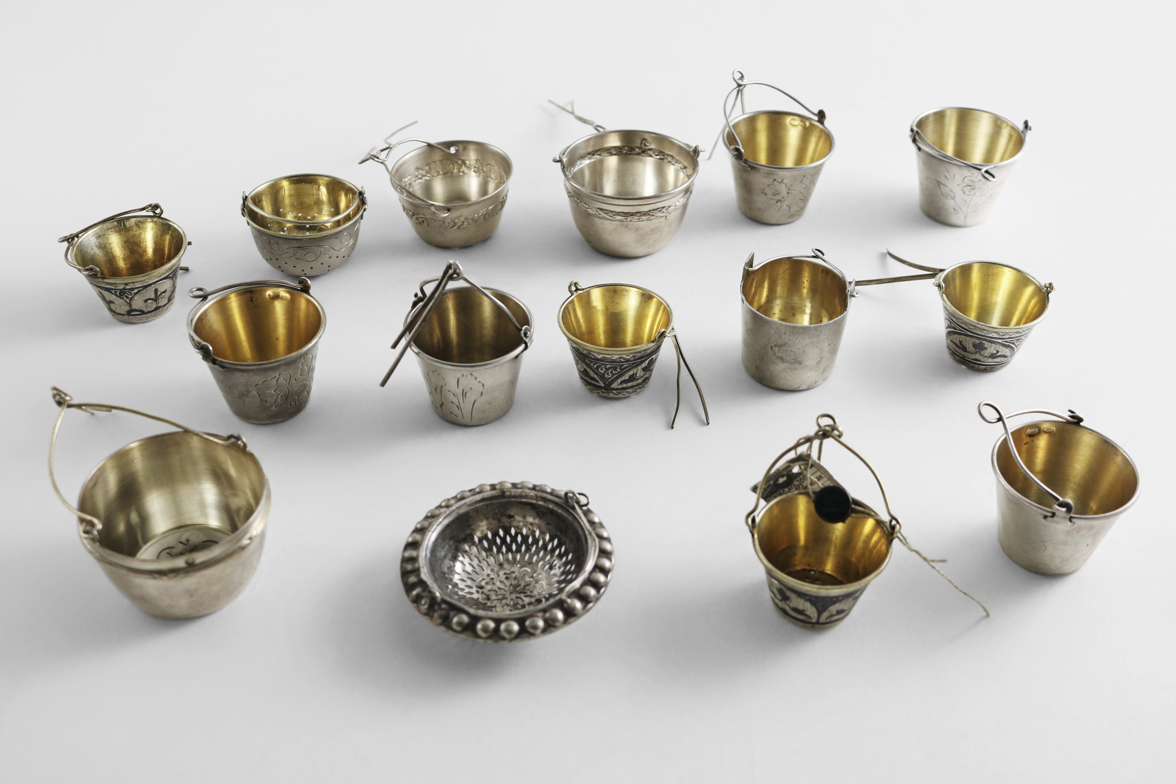 FOUR EARLY 20TH CENTURY FRENCH & ELEVEN SOVIET TEA STRAINERS (mostly pail-shaped, with a clip for