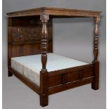 CAROLEAN STYLE OAK FULL TESTER, FOUR POSTER BED, the panelled cover supported by turned legs and