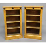 PAIR OF BIEDERMEIER STYLE MAPLE OPEN BOOKCASES, the frieze with three ebonised roundels above