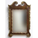 GEORGE III STYLE WALL MIRROR, the shaped rectangular plate in a mahogany and parcel gilt frame,