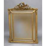 FRENCH GILT GESSO CUSHION MIRROR, 19th century, the bevelled glass plates below a gilt torch and