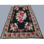KARABAGH KILIM, South Caucasus, circa 1950, the ink black field centred by a naturalistic floral