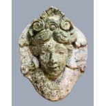 RECONSTITUTED STONE WALL PLAQUE, the female face with a scrolling hair piece on a shaped oval