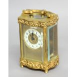 FOUR PANEL GILT METAL CARRIAGE TIME PIECE, the ivorine dial in a gilt frame on an eight day