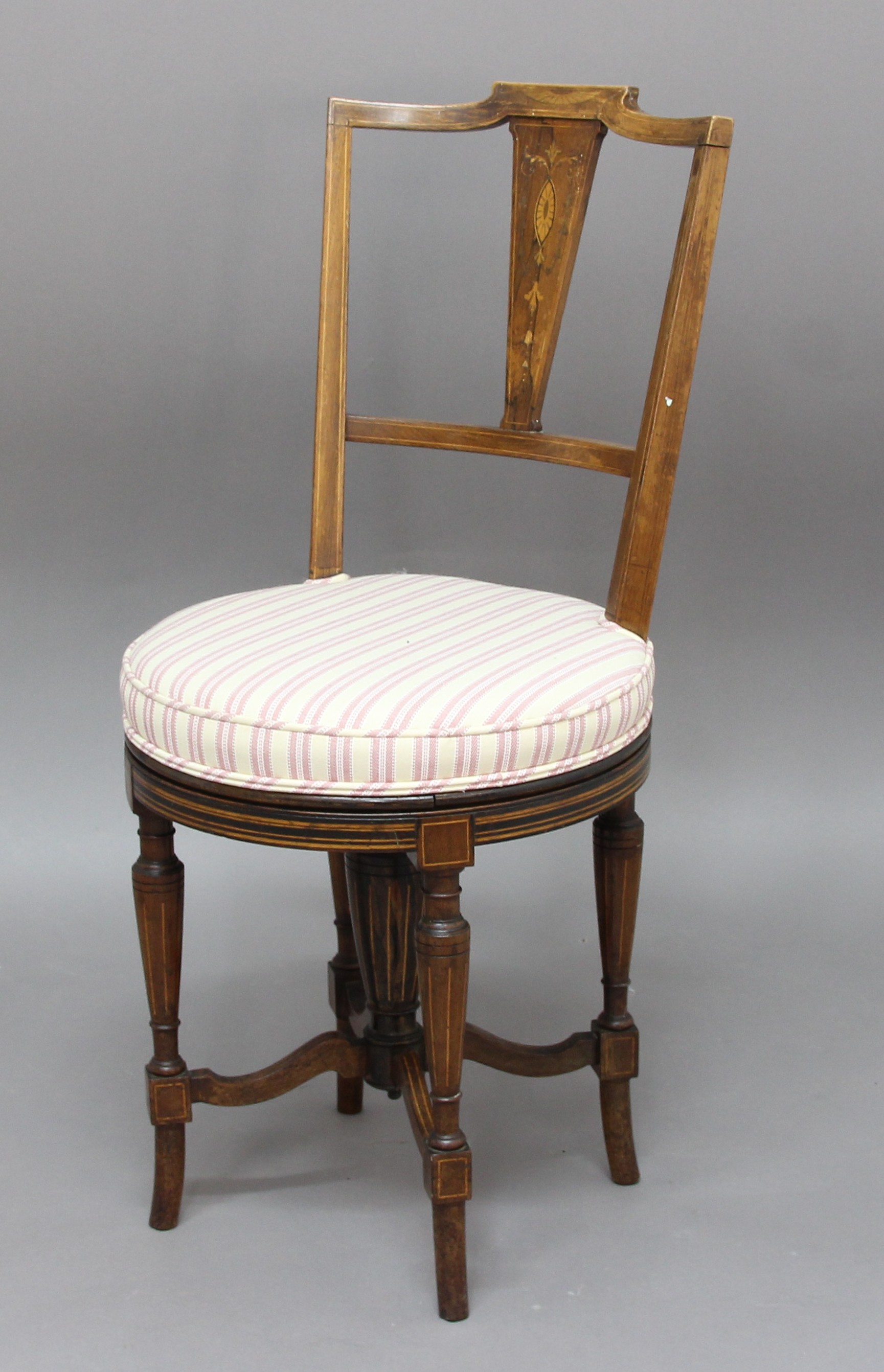 VICTORIAN ROSEWOOD AND INLAID REVOLVING MUSIC CHAIR, the inlaid back above a circular seat, tapering