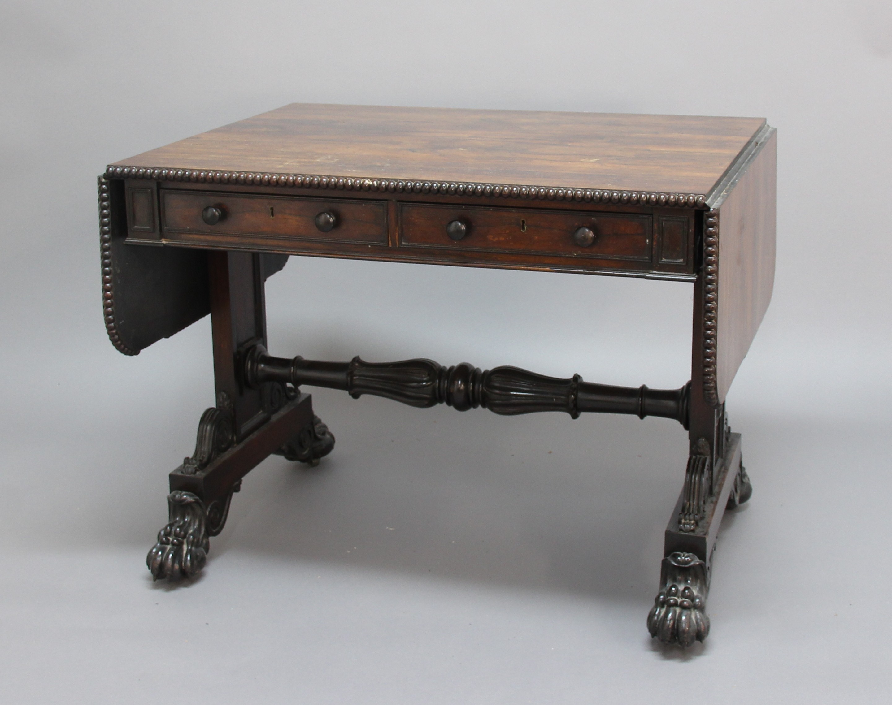 REGENCY ROSEWOOD SOFA TABLE, the drop leaf top with beaded moulding over two frieze drawers and