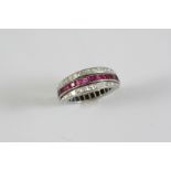 A SAPPHIRE, RUBY AND DIAMOND SWIVEL ETERNITY RING set with calibre-cut sapphires and rubies and
