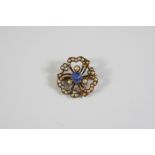 A SAPPHIRE AND SEED PEARL TREFOIL FLOWERHEAD BROOCH the circular-cut sapphire is set within a