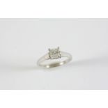 A DIAMOND SOLITAIRE RING the square-shaped diamond weighs 1.0 carats and is set in platinum. Size