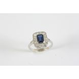 A SAPPHIRE AND DIAMOND CLUSTER RING the cut cornered rectangular-shaped sapphire is set within a