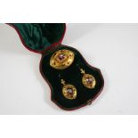 A VICTORIAN GARNET AND GOLD BROOCH set with an oval foil backed garnet mounted with a small pearl,