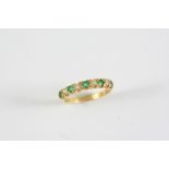 AN EMERALD AND DIAMOND HALF HOOP RING the five circular-cut emeralds are set with four circular-