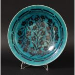 PERSIAN PLATE, late 19th or 20th century, painted with flowering foliage under a turquoise glaze,