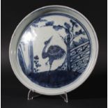 JAPANSE BLUE AND WHITE DISH, painted with a stork by a fence, diameter 23cm