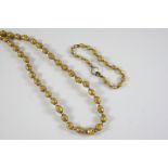 AN ETRUSCAN GOLD BEAD NECKLACE the oval-shaped beads with applied gold decoration, together with a