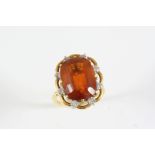 A CITRINE AND DIAMOND CLUSTER RING the oval-shaped citrine is set within a surround of eight