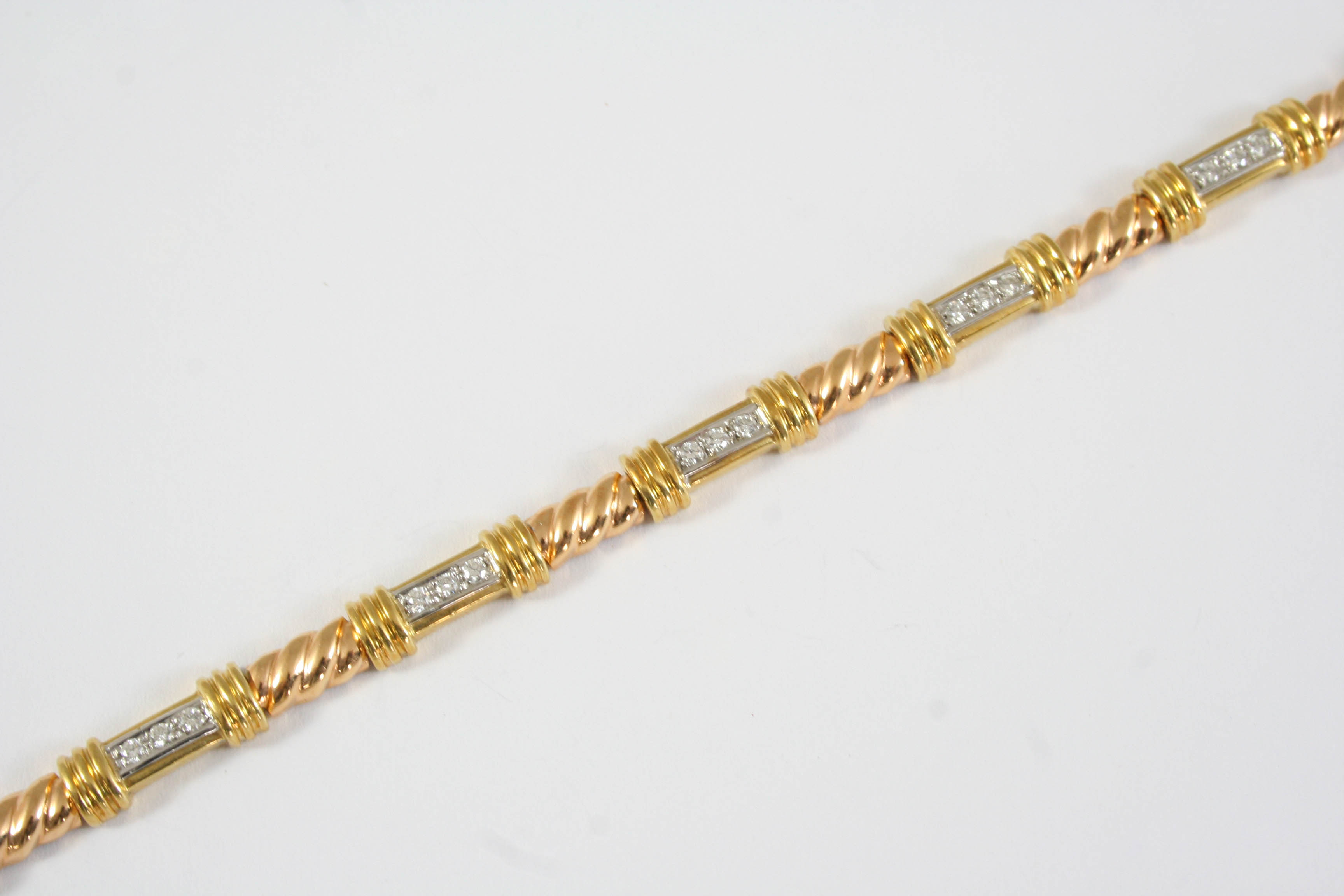 A DIAMOND AND 18CT GOLD BRACELET the rope link bracelet is mounted with seven gold sections each