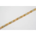 A DIAMOND AND 18CT GOLD BRACELET the rope link bracelet is mounted with seven gold sections each