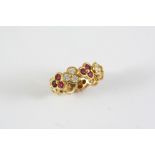 A RUBY AND DIAMOND FULL CIRCLE ETERNITY RING of trefoil design, set with circular-cut rubies and