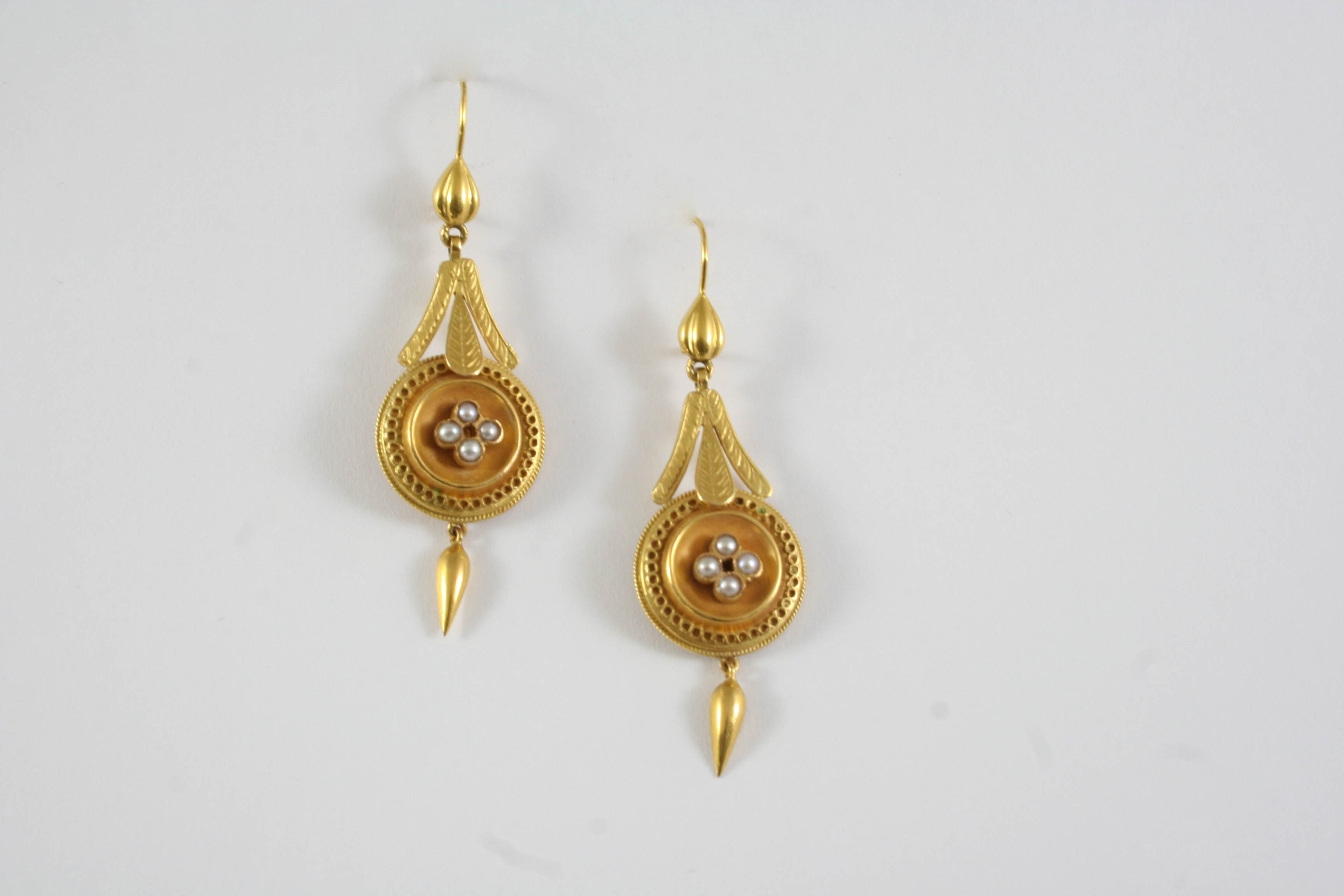 A PAIR OF GOLD AND PEARL DROP EARRINGS each earring with rope and foliate decoration, centred with a