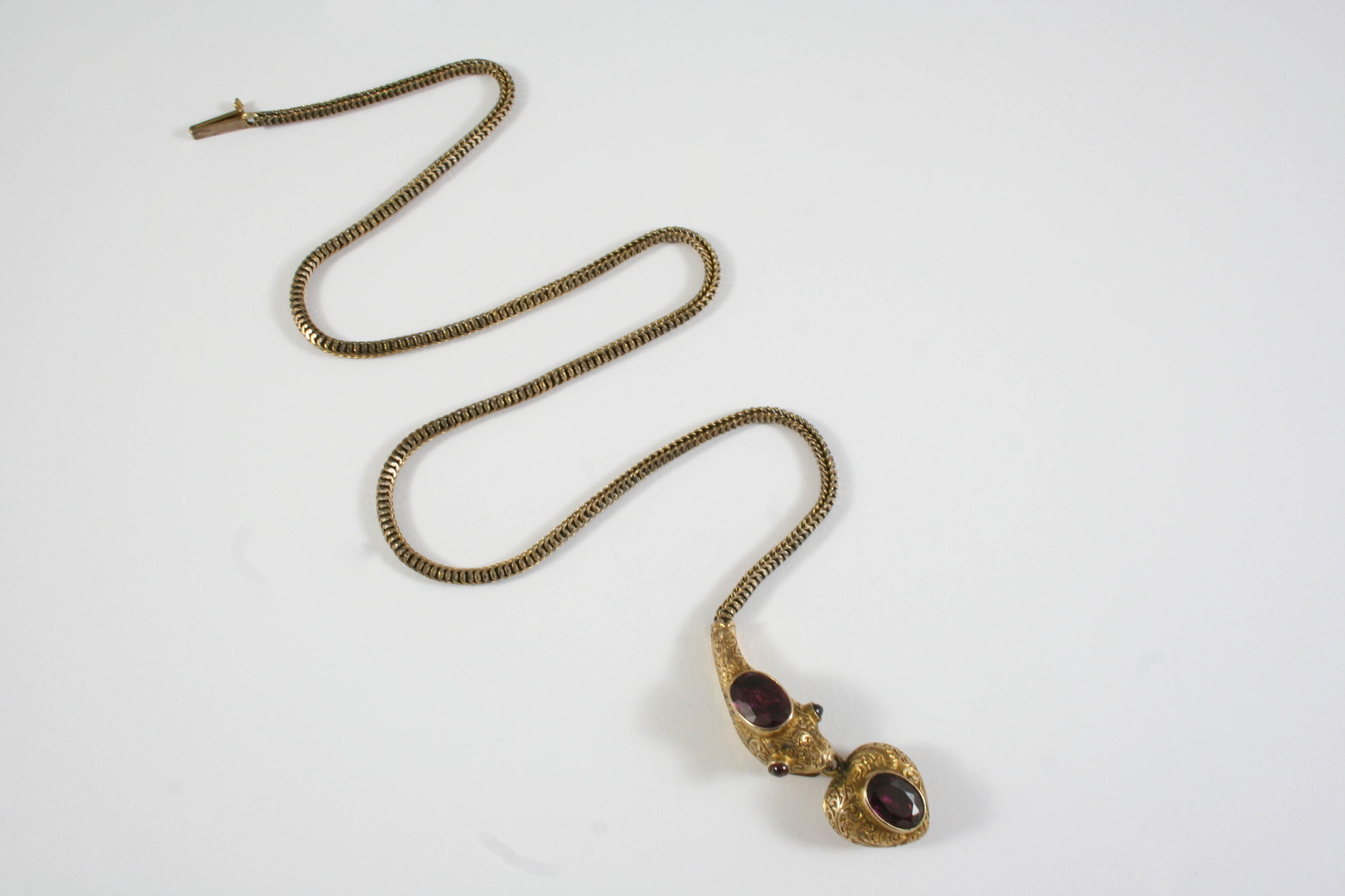 A VICTORIAN GARNET AND GOLD SNAKE NECKLACE the gold foliate engraved head mounted with an oval - Image 2 of 2