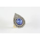 A TANZANITE AND DIAMOND PEAR-SHAPED RING the oval cabochon tanzanite is set within a pear-shaped