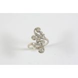 A DIAMOND RING of swirl design, set overall with graduated circular-cut diamonds. Size K