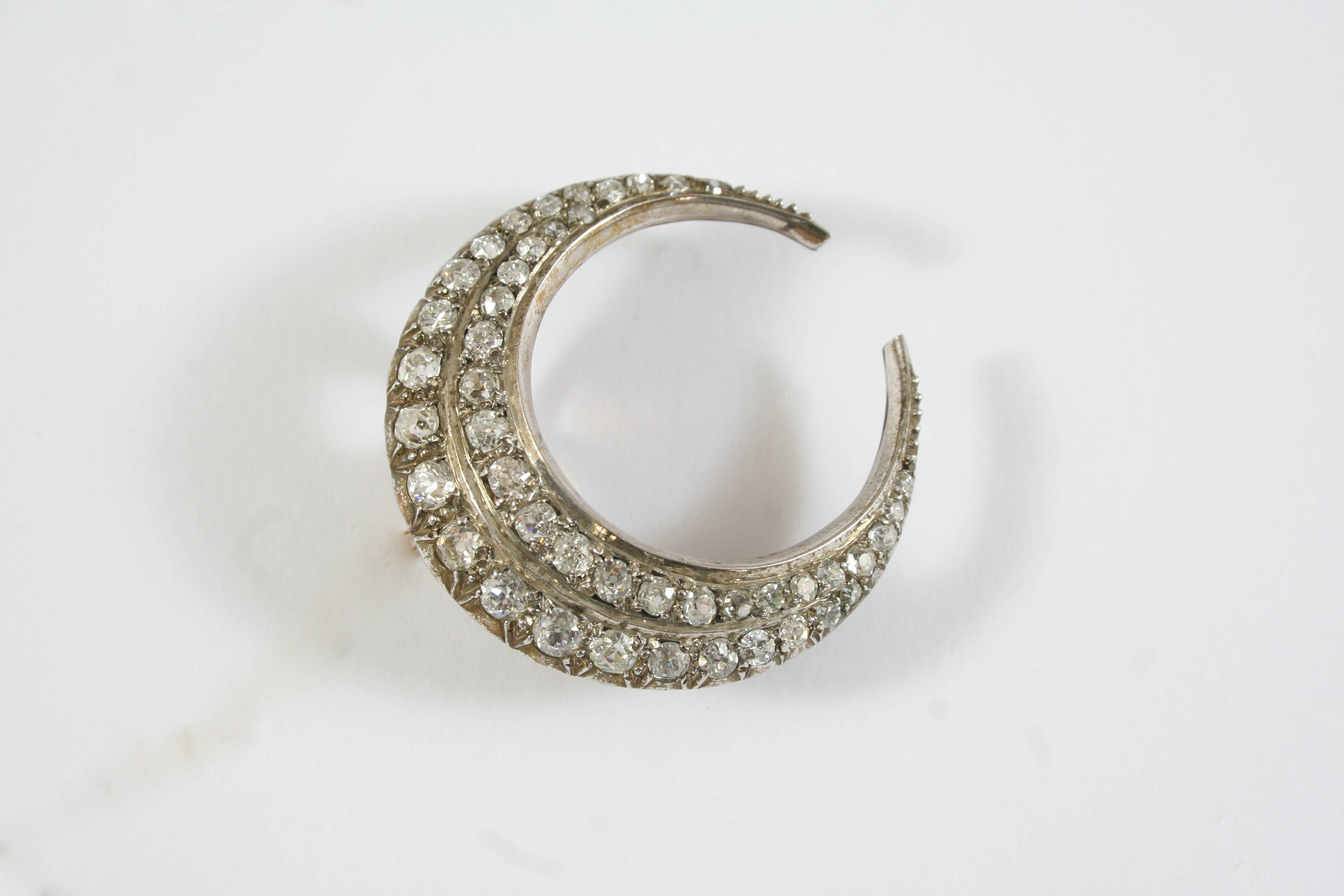 A VICTORIAN DIAMOND CLOSED CRESCENT BROOCH formed as two rows of graduated old cushion-shaped