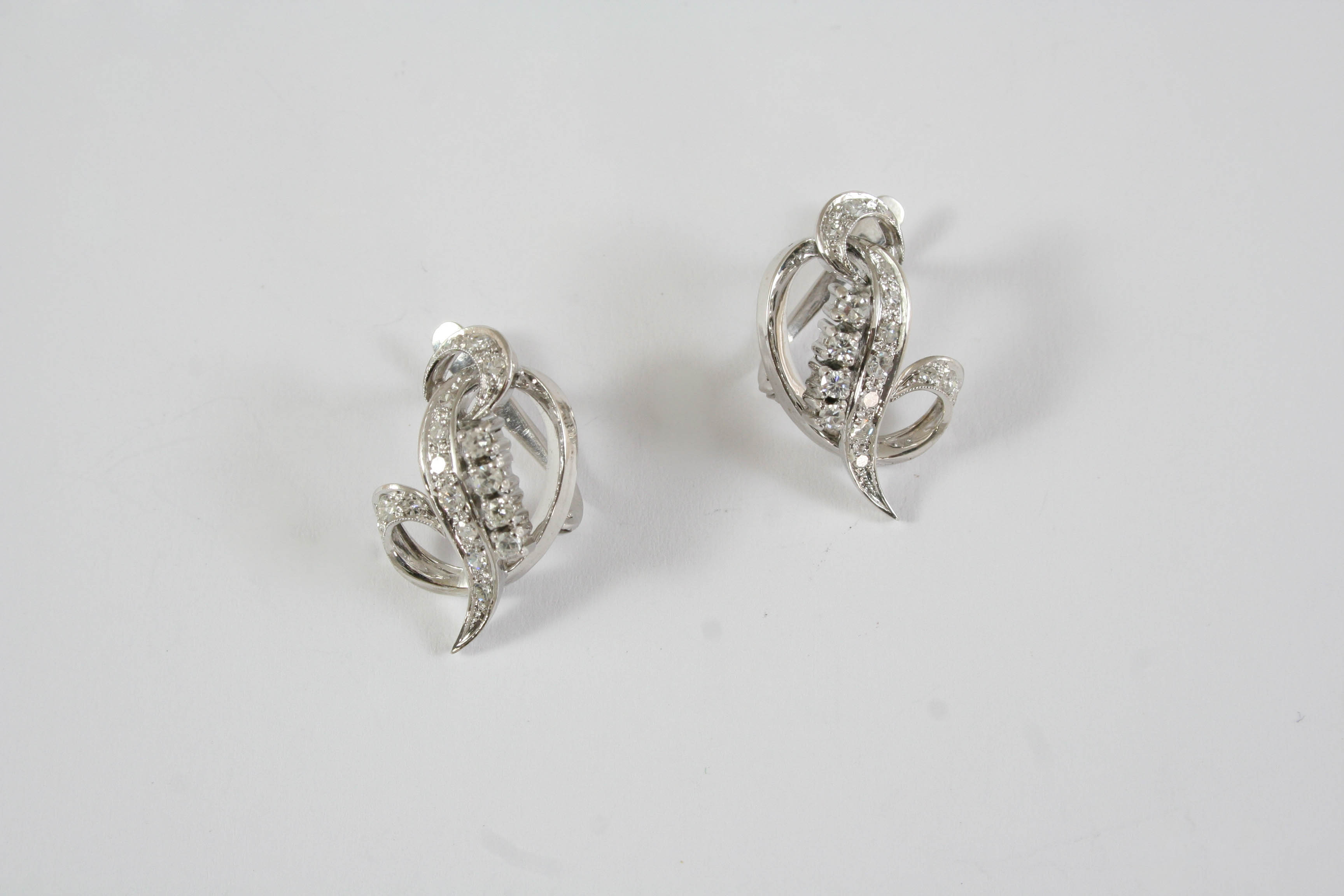 A PAIR OF DIAMOND EARRINGS of scrolling form, each set with circular-cut diamonds in white gold, 2.